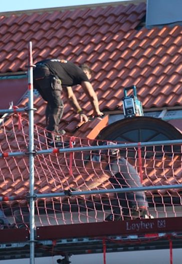 Pose de tuiles sur un chantier de couverture