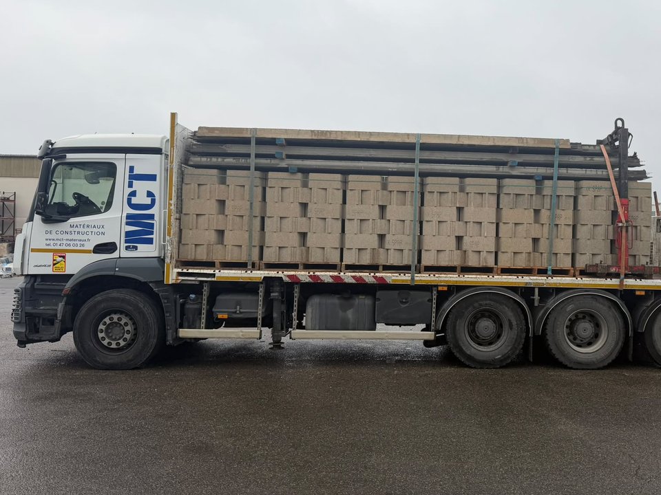 Étape 1 : camion-grue MCT chargé de blocs à bancher et de poutrelles
