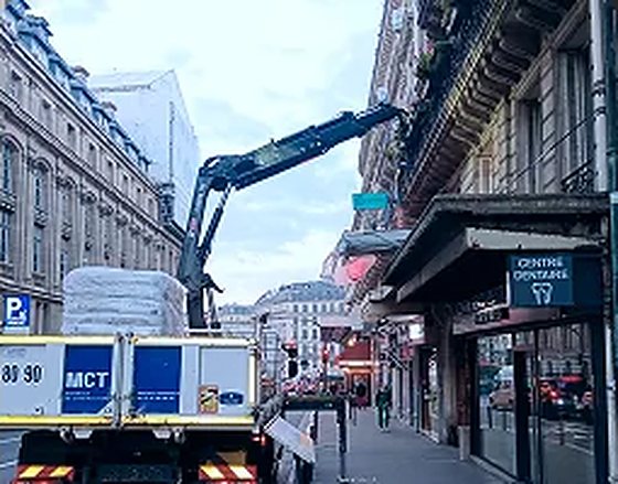 Camion-grue MCT livrant des matériaux dans une rue de Paris